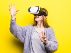 Teenage girl with virtual reality headset on yellow background
